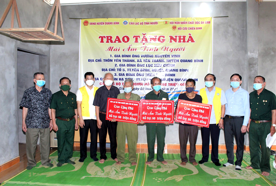 Đại diện các đơn vị trao tiền hỗ trợ cho hội viên làm nhà ở tại huyện Quang Bình.