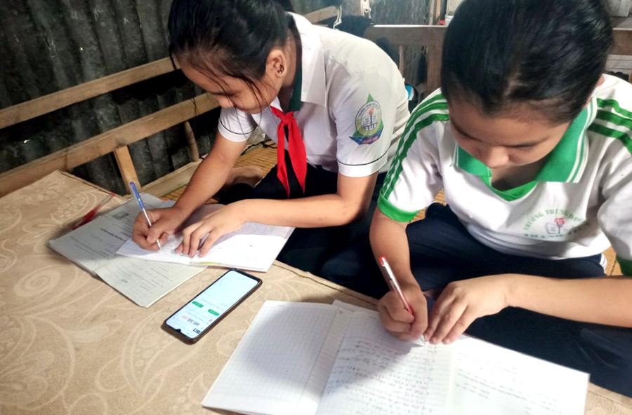 Hai hoc sinh ở Cần Thơ phải học online chung bằng 1 chiếc điện thoại - ảnh Đức Duy.