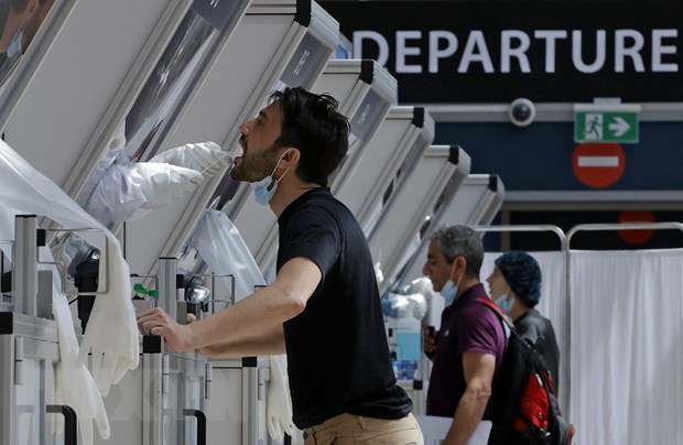 Nhân viên y tế lấy mẫu xét nghiệm COVID-19 cho hành khách tại sân bay Ben Gurion, gần Tel Aviv, Israel ngày 6/4/2021. 