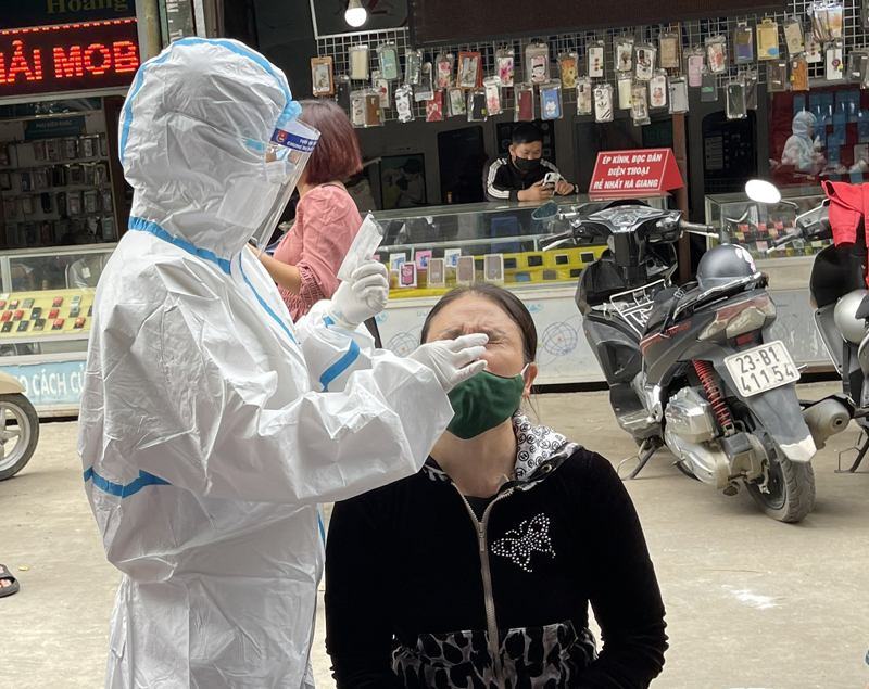 Lực lượng y tế thành phố lấy mẫu test nhanh cho người dân buôn bán tại chợ thành phố Hà Giang. Ảnh QH