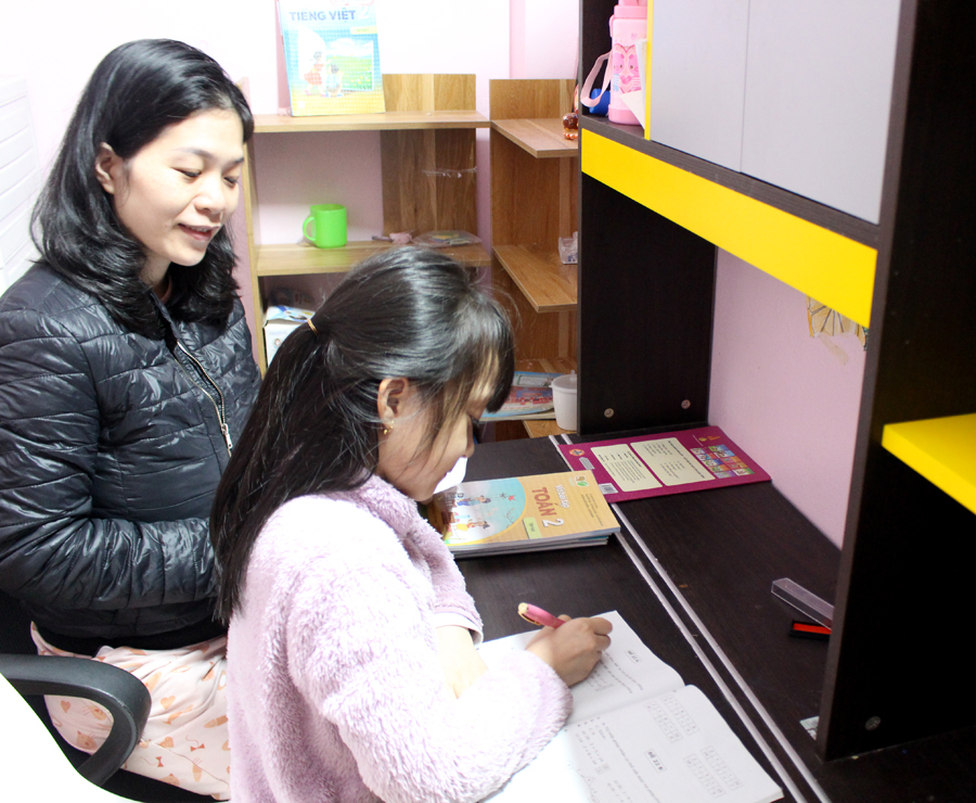 Em Nguyễn Hoàng Ngân, học sinh lớp 2A1, Trường Tiểu học Kim Đồng (thành phố Hà Giang) được mẹ hướng dẫn học bài.