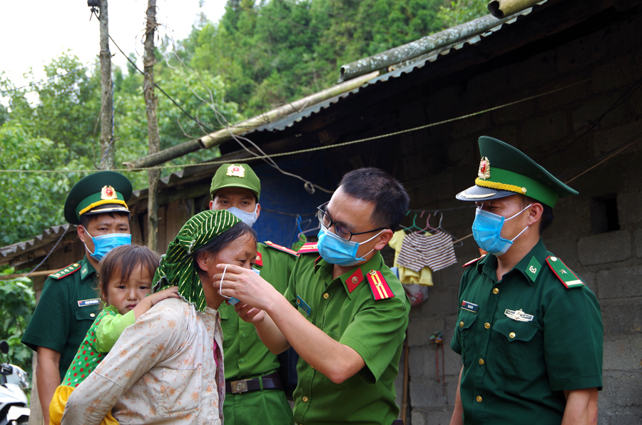 Lực lượng Công an phối hợp với Bộ đội Biên phòng hướng dẫn người dân đeo khẩu trang phòng, chống dịch.