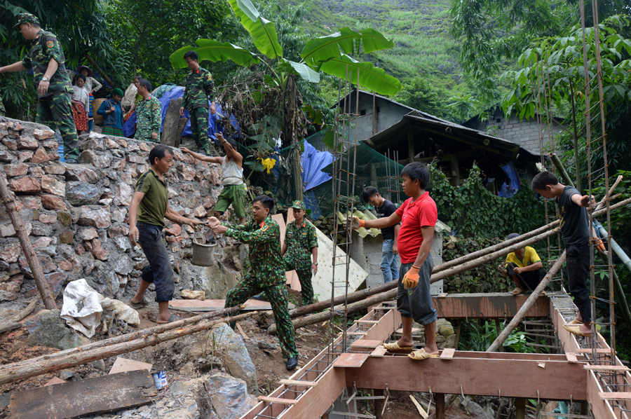 Cán bộ, chiến sĩ lực lượng vũ trang hỗ trợ xây dựng nhà ở cho người có công tại xã Pả Vi (Mèo Vạc). 						Ảnh: TƯ LIỆU