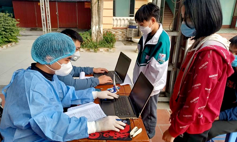 Lực lượng y tế phường Nguyễn Trãi (TPHG) lấy thông tin trước khi tiêm vác xin mũi 2 cho các em học sinh Trường THCS Lê Lợi. Ảnh: QH