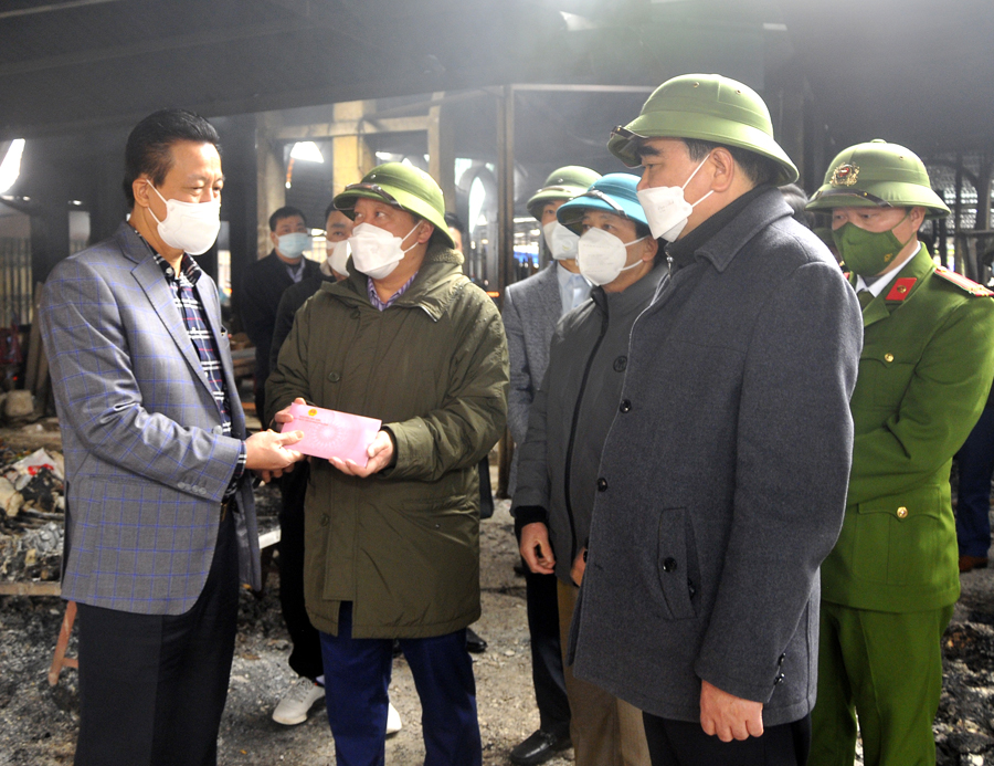 Chủ tịch UBND tỉnh Nguyễn Văn Sơn trao tiền hỗ trợ huyện Quản Bạ khắc phục thiệt hại của vụ cháy.