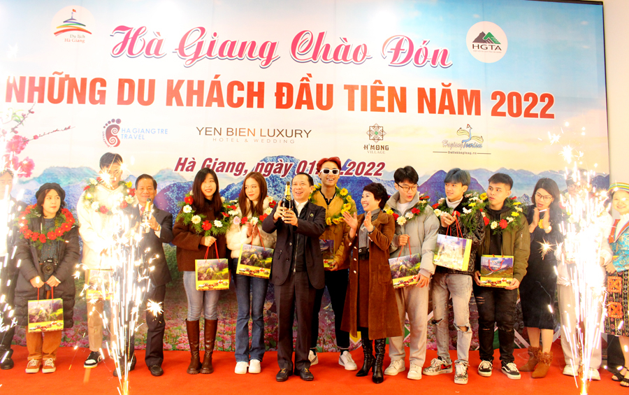 Đồng chí Trần Đức Quý, Phó Chủ tịch UBND tỉnh chụp ảnh lưu niệm với những du khách đầu tiên đến du lịch tại tỉnh Hà Giang năm 2022.